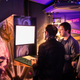 People at last year’s GamesAreForEveryone gathered around a hybrid arcade cabinet.